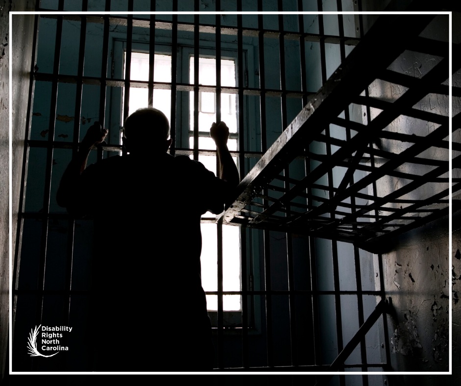 silhouette of prisoner in cell looking out bars of window