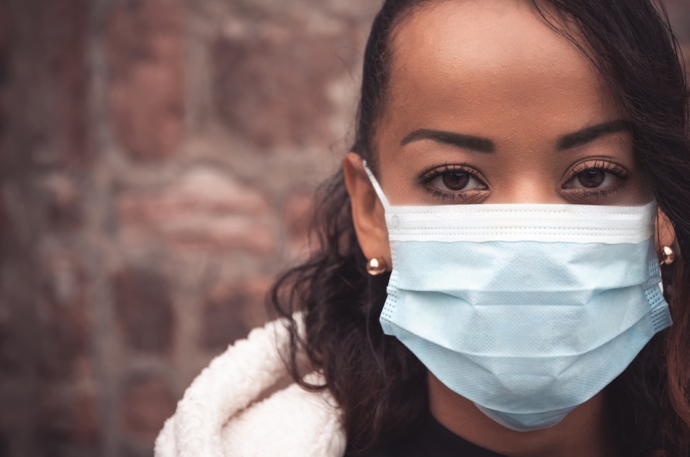 black woman wearing a mask, worried about eviction