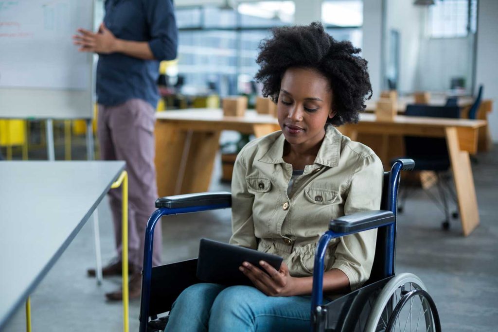 Black executive woman in wheelchair holds tablet