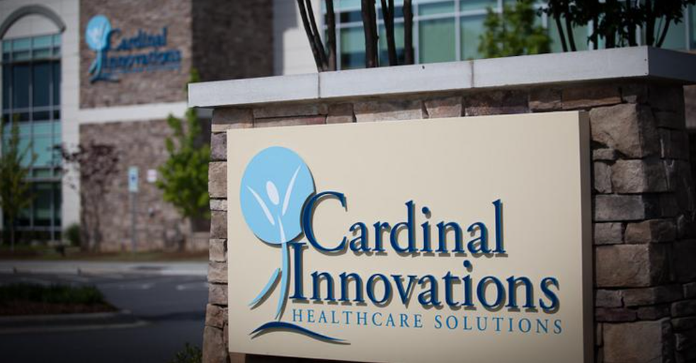 Sign outside of the Cardinal innnovations office building, reads "Cardinal Innovations Healthcare solutions, on brick facade