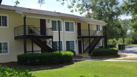 a two story yellow apartment building with 4 units