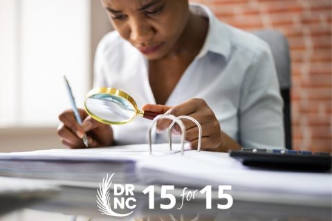 2 woman with magnifying glass inquisitively looking at a binder