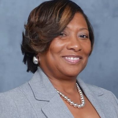 Barbara Daniels wearing a gray blazer and pearls