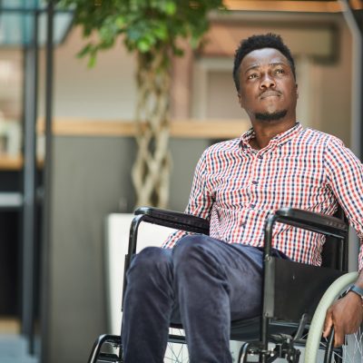 Black man in wheelchair looks to his left
