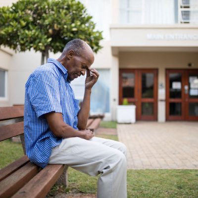 Black man sits in front of community building