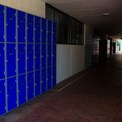 Blue lockers in an empty school hallway