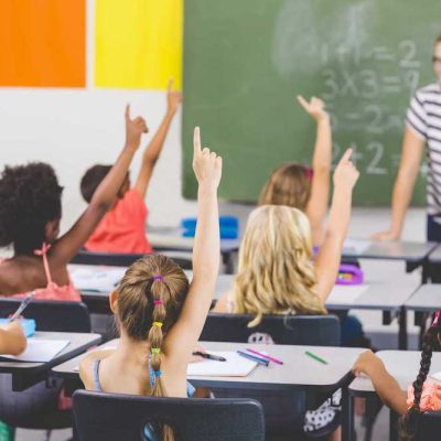 Children in school raise hands