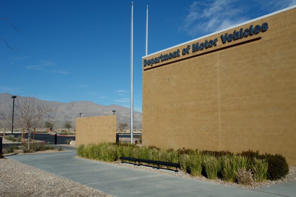 The side of a large building with the words "Department of Motor Vehicles" written across the top left corner.