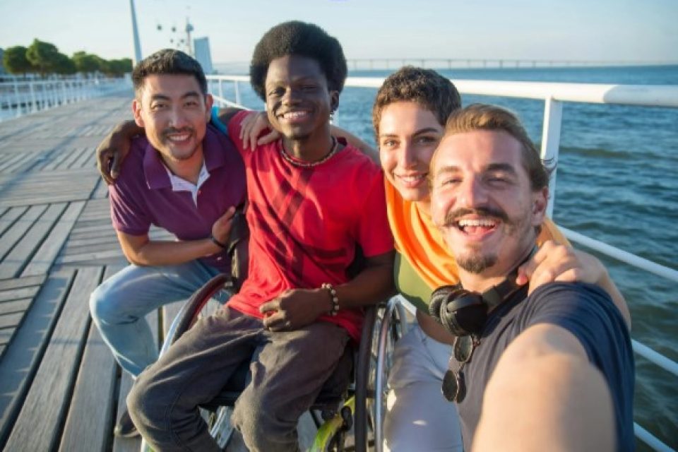 Diverse group of friends with different disabilities pose for a group photo