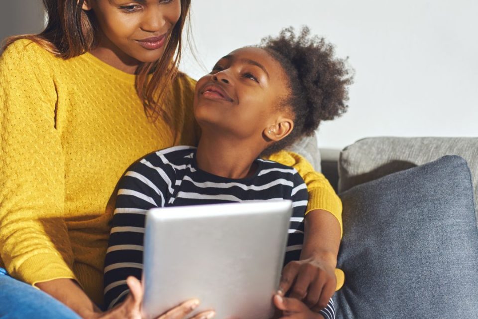 Black mother and child looking at a device
