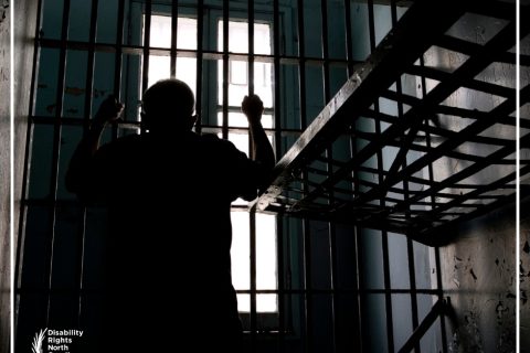 silhouette of prisoner in cell looking out bars of window