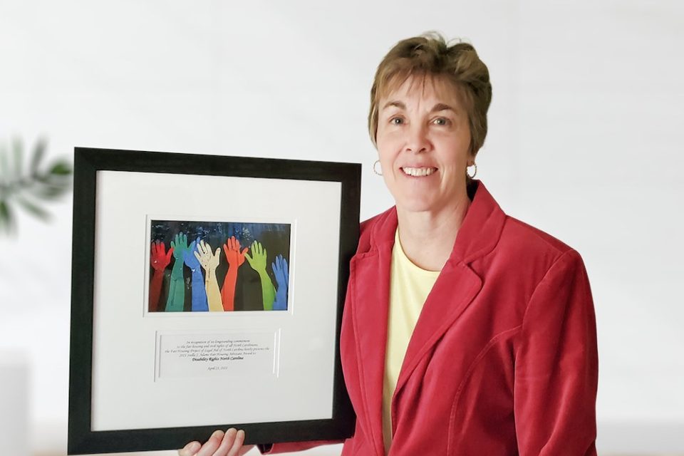 Lisa nesbitt holding the fair housing advocacy award
