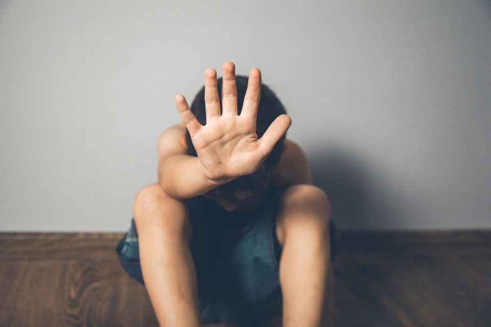 Young student sits in corner with head down