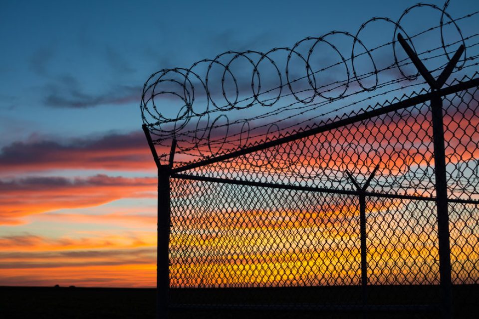 Prison fence at sunset