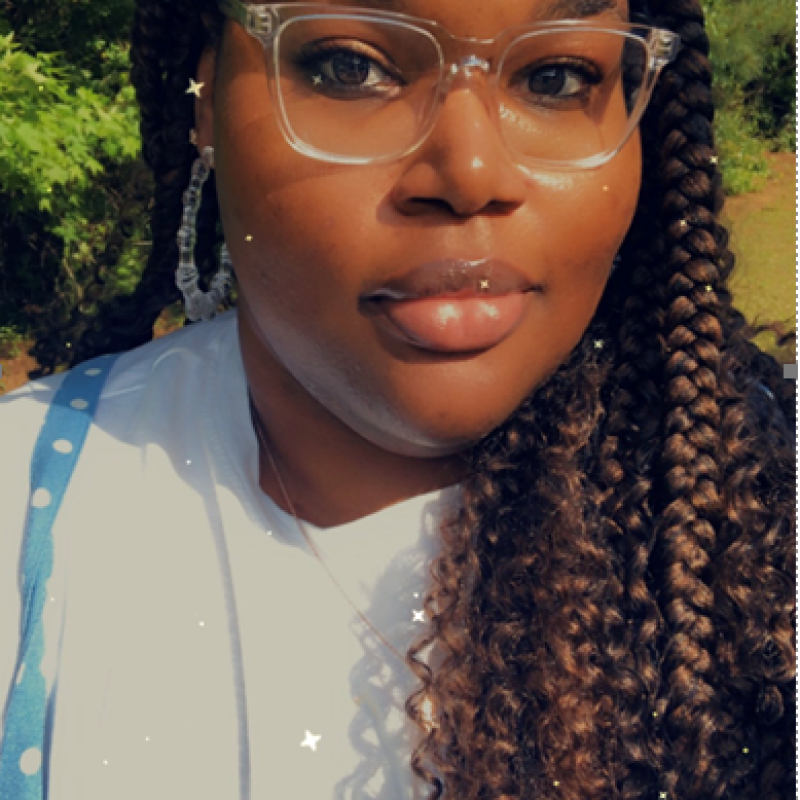 Picture of a young woman wearing glasses with braids.