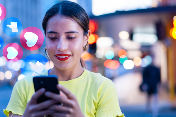 Social media policy (1) woman on phone in busy evening cityscape.