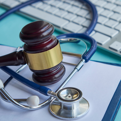 A gavel and stethoscope on top of a computer keyboard