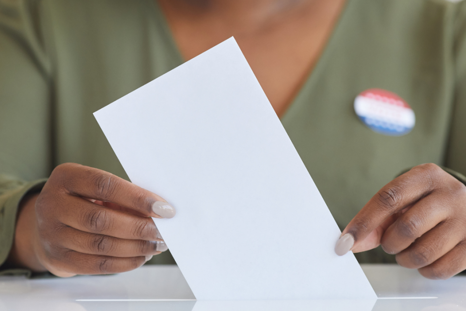 Woman placing ballot in box