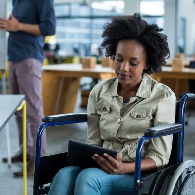 Black executive woman in wheelchair holds tablet