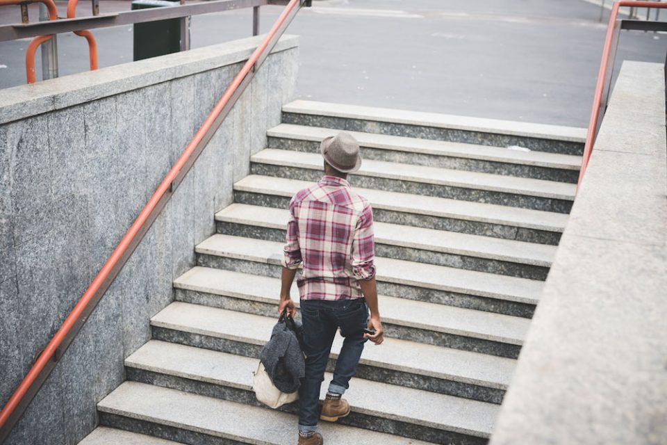 black man walks up a flight of stairs