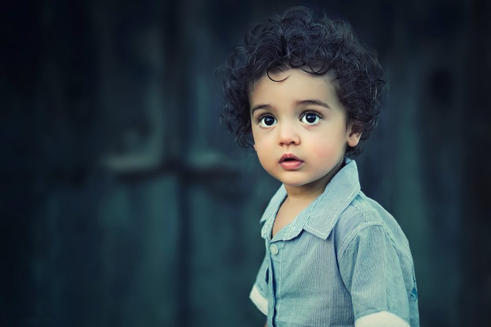 young toddler with dark brown eyes and curly hair